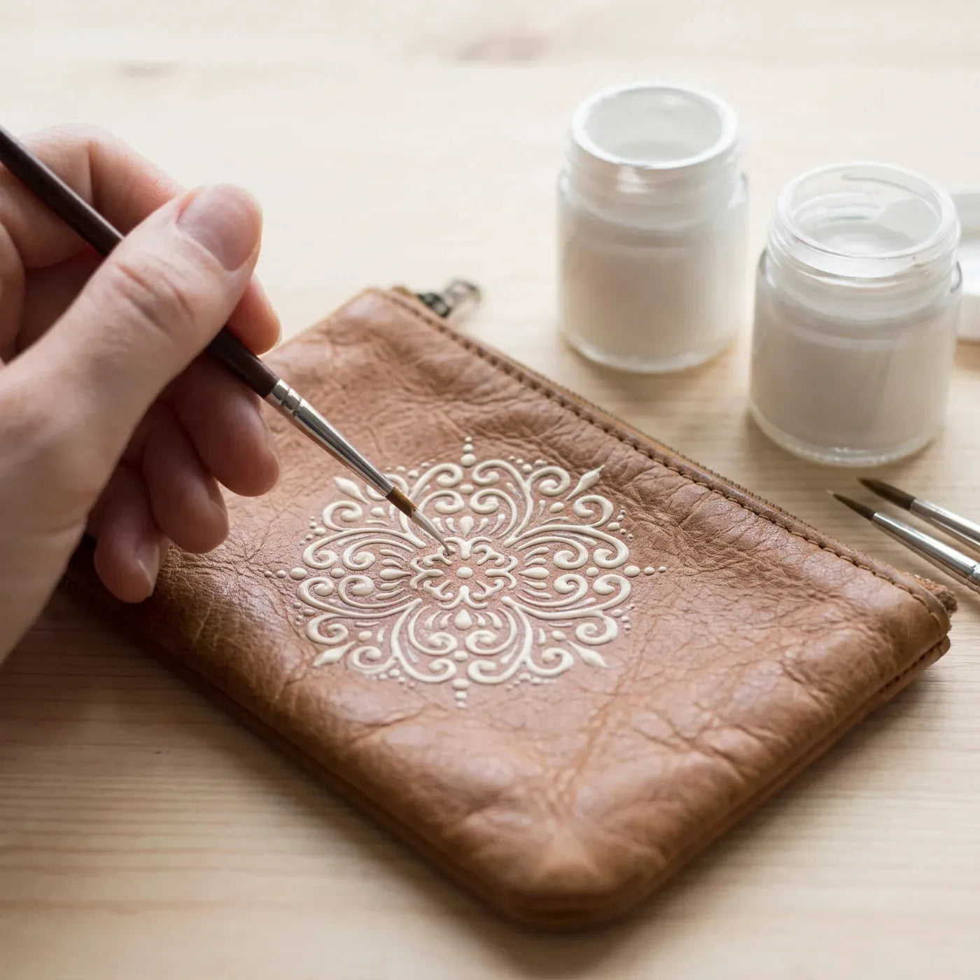 Jednobarevný ornament malovaný barvou na textil na kožené peněžence